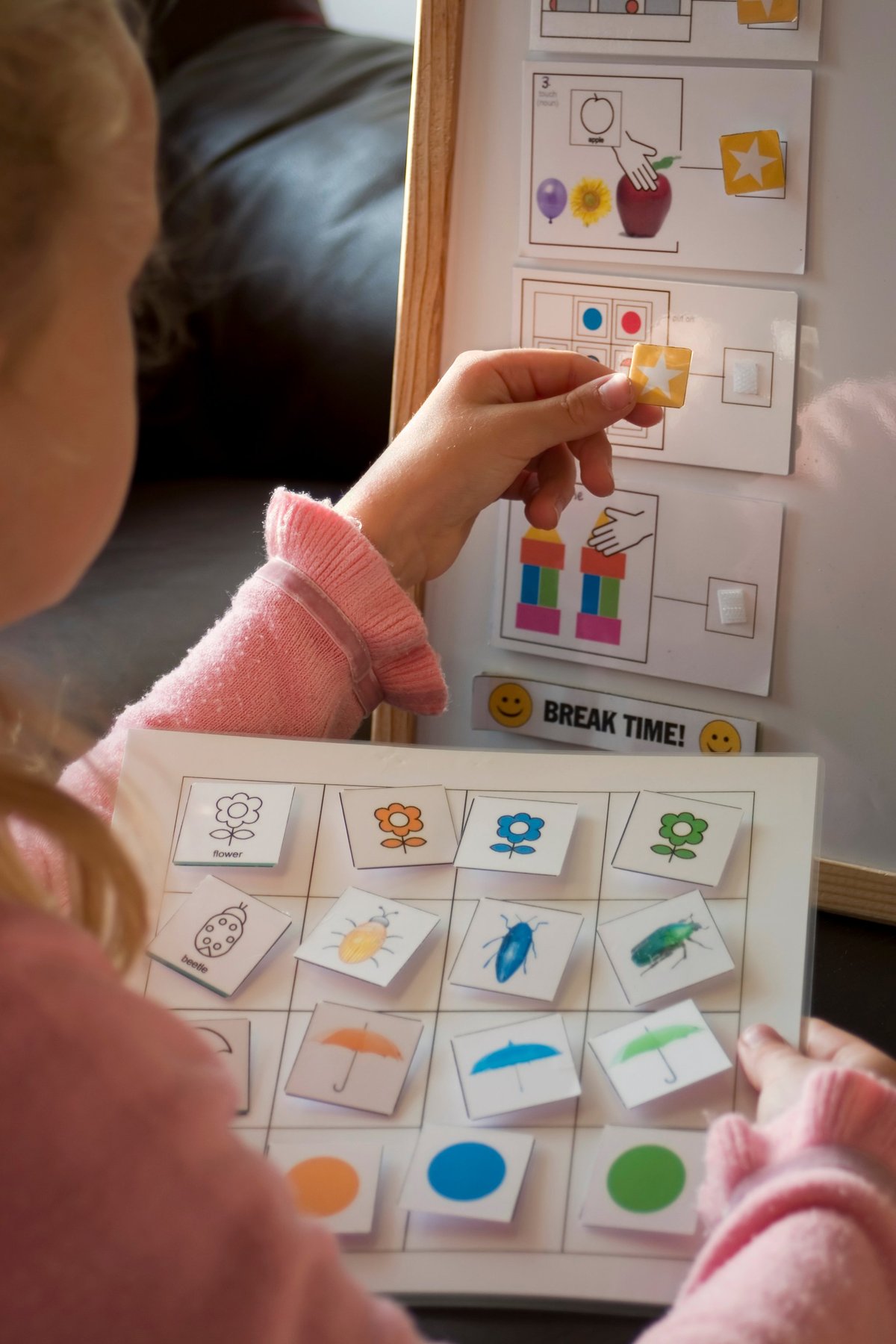 Child checking a picture schedule board used for therapy support
