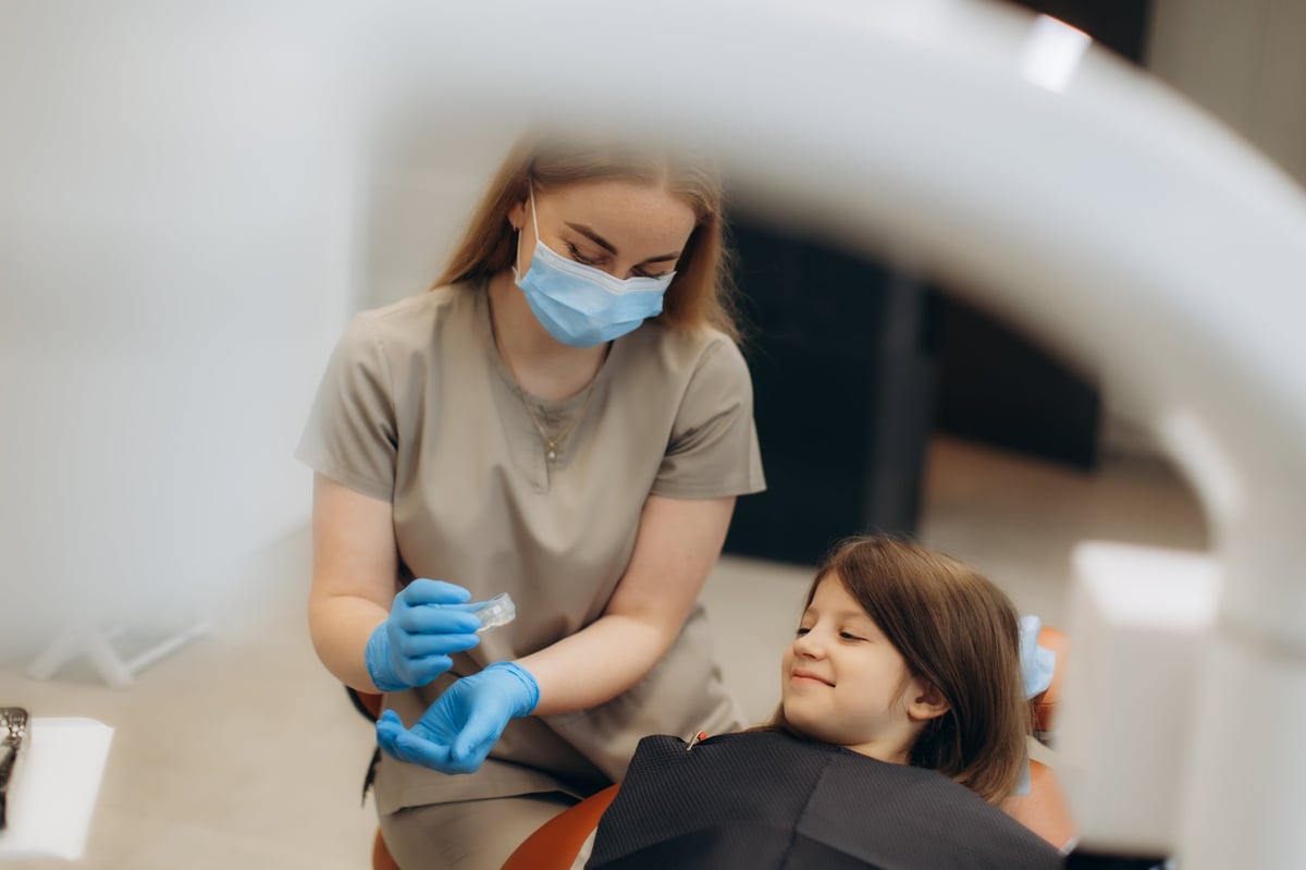 Dentist preparing materials for a child during a dental appointment