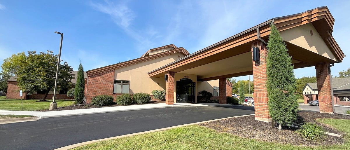 Exterior of the New Heights Therapy pediatric therapy clinic in Topeka, Kansas — a modern brick building with a covered entry canopy and green landscaping