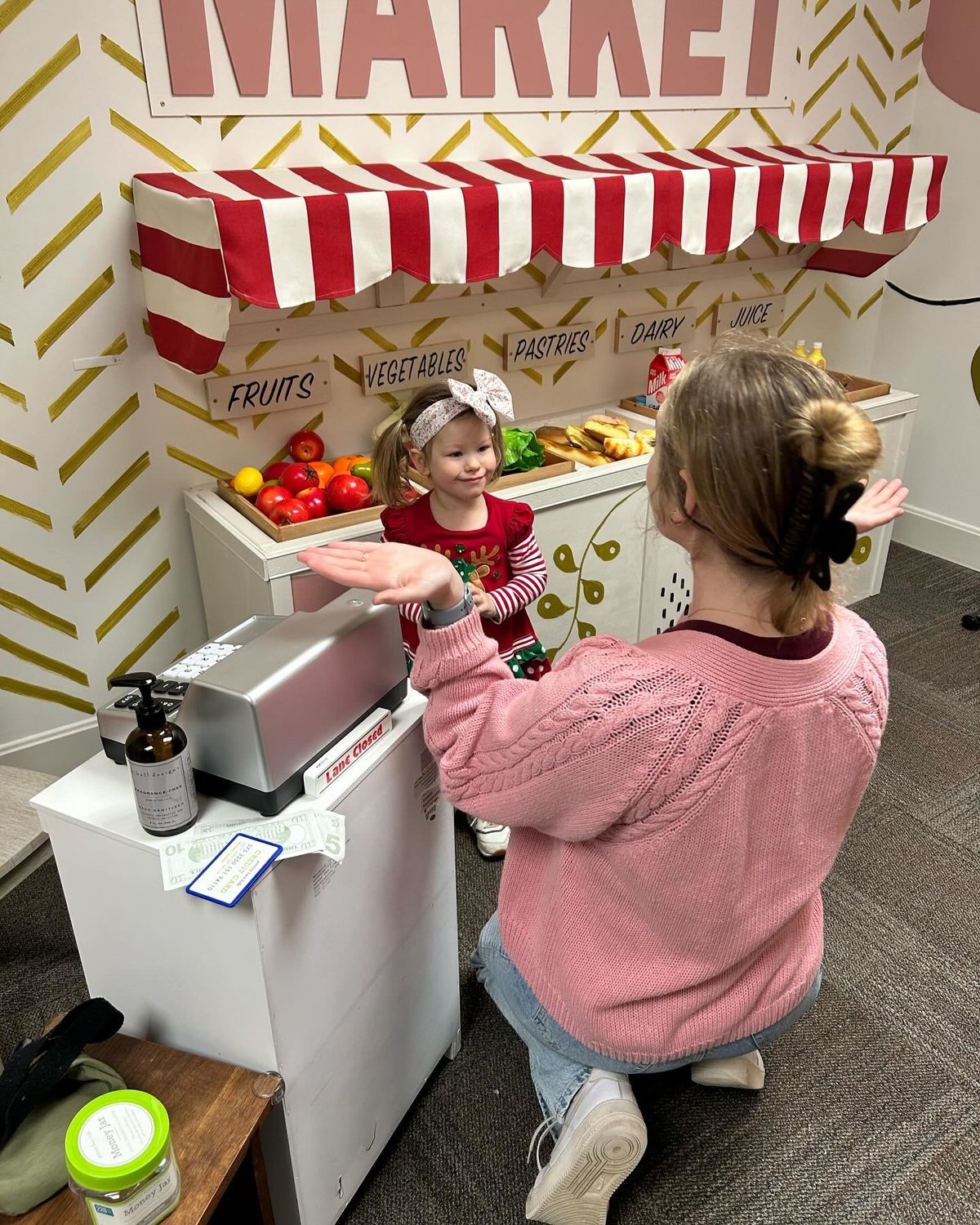 Two young children role-playing at a toy market stand during a speech therapy session — building language and social communication at New Heights Therapy in Kansas