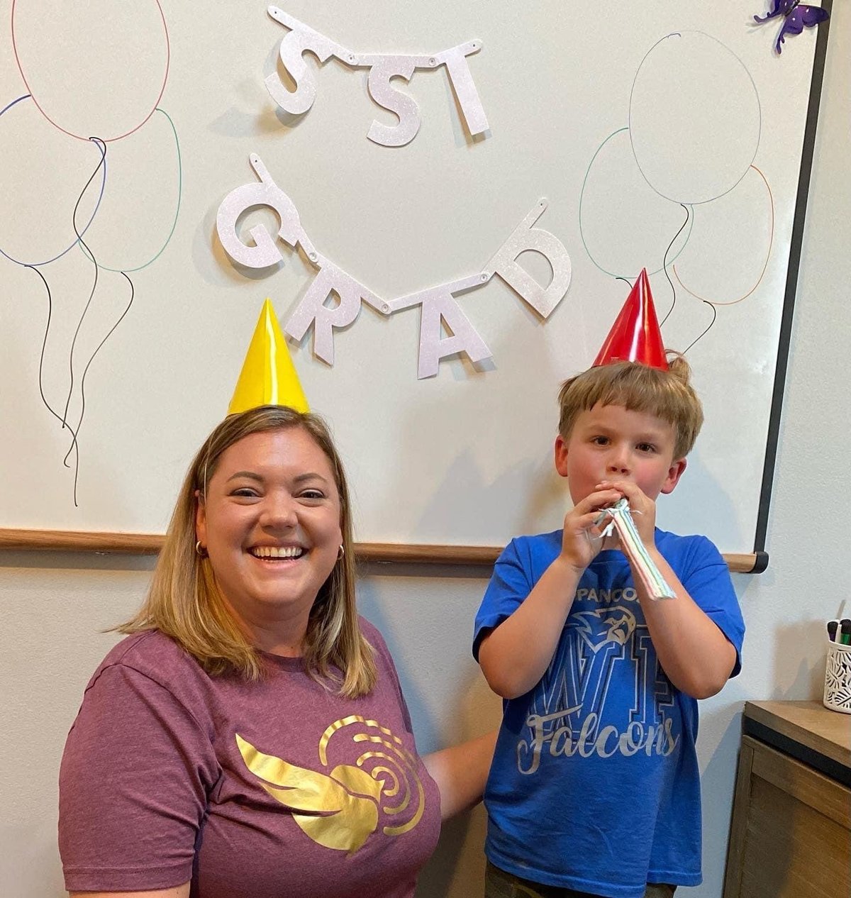 Two patients and a speech-language pathologist in party hats celebrating a speech therapy graduation with Grad banners at New Heights Therapy