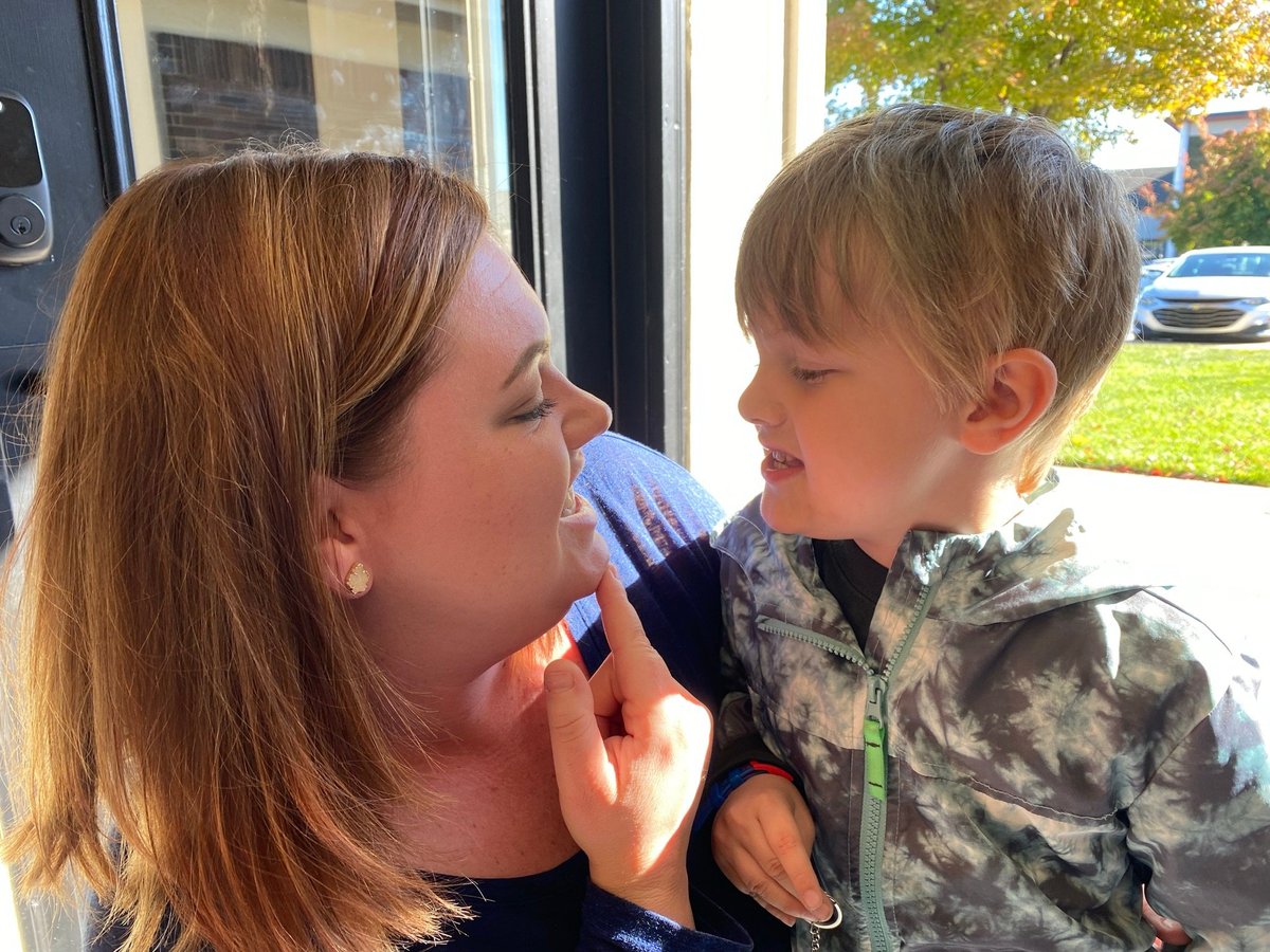 Speech therapist holding an infant by the window of a therapy room at New Heights Therapy, supporting early communication in Kansas