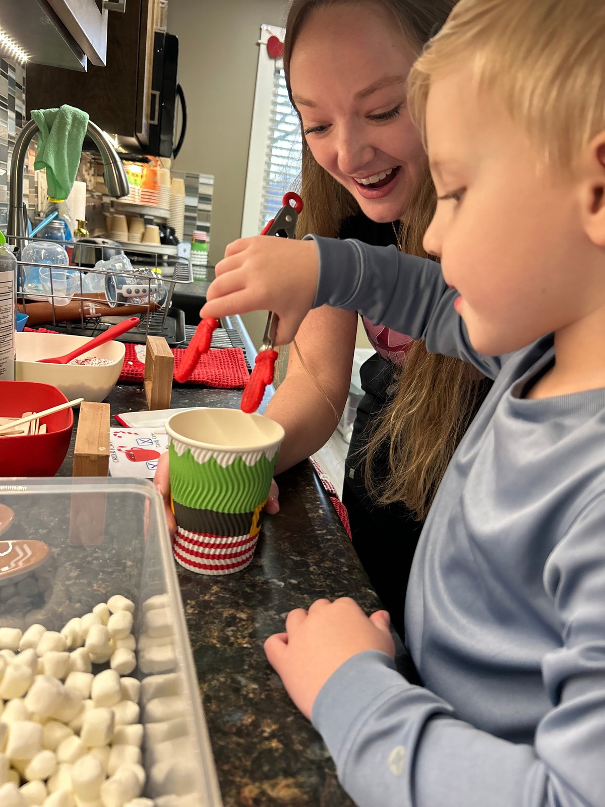 Adult and child decorating cupcakes together in the teaching kitchen at New Heights Therapy in Kansas — practicing food skills during pediatric feeding therapy